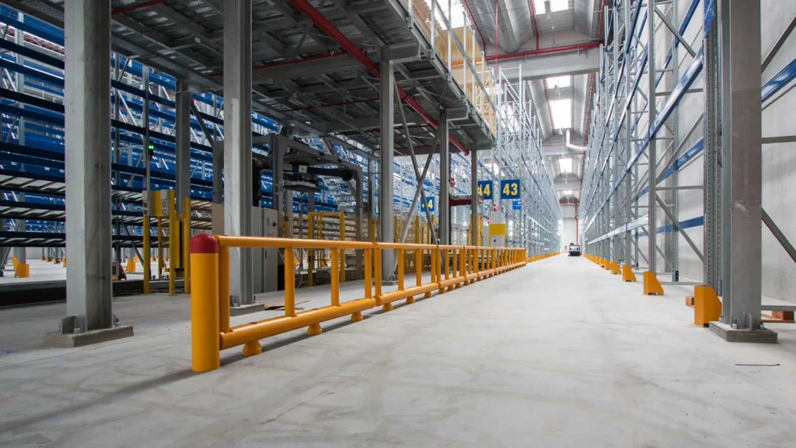 Impact barrier along an aisle with racking